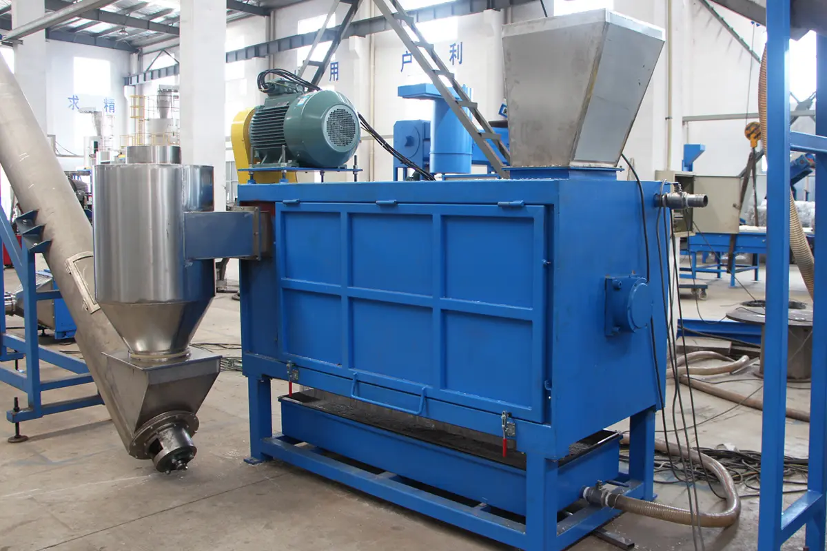 a centrifugal dryer dewatering machine. Such machines are typically used in industrial settings to remove moisture from materials using high-speed spinning. This process helps in reducing the moisture content of various products, making them easier to process further or package. The machine is robust, featuring a large, blue rectangular frame housing the spinning mechanism, with a motor mounted on top and various inlets and outlets for the material and water.