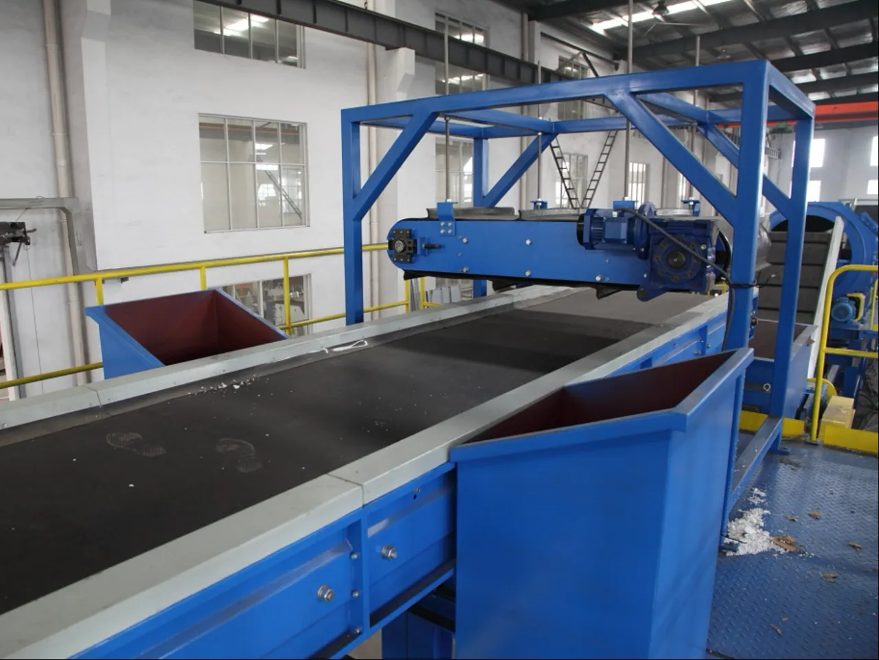 Industrial magnetic separator in operation on a conveyor belt system, used for removing ferrous materials in recycling and mining processes.