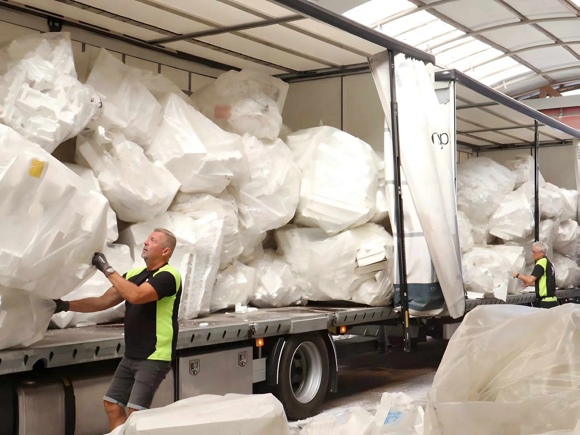 Industrial waste foam recycling image of expanded polystyrene (EPS) foam waste ready for processing with compressed foam blocks stacked next to it.